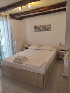 スキアトスタウンにあるSkiathos island houseの白いシーツが敷かれた大きなベッドのある寝室