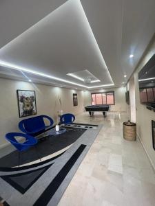 - un salon avec des chaises bleues et un billard dans l'établissement Villa contemporaine, à Marrakech