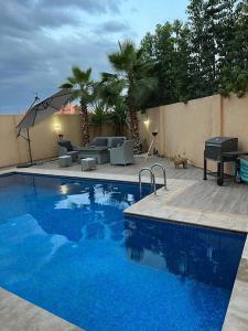 une grande piscine bleue à côté d'un patio dans l'établissement Villa contemporaine, à Marrakech