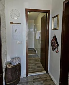 a bathroom with a shower and a clock on the wall at Small House Postup in Orebić +27 photos