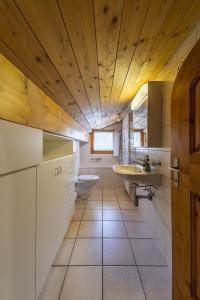 uma casa de banho com armários brancos e um tecto de madeira em Chesa Susi - Celerina em Celerina
