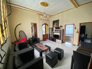 a living room with couches and a table and a tv at NN Homestay in Tlekung