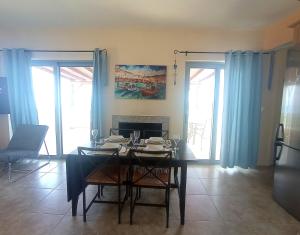 une salle à manger avec une table et des rideaux bleus dans l'établissement Casa al mar, à Galaxidi