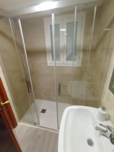 um chuveiro com uma porta de vidro ao lado de um lavatório em Apartamento kuki en Rincón de Loix em Benidorm