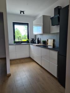 a kitchen with white cabinets and a window at Zacisze w Karkonoszach in Karpacz