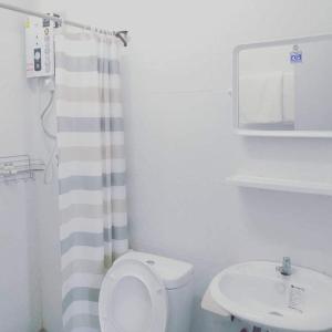 a bathroom with a white toilet and a sink at บ้านสวนปลายนา Ban suan pailna in Ban Kaeng Tat Sai