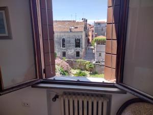 ein offenes Fenster mit Blick auf ein Gebäude in der Unterkunft Stefy's rooms in Venedig