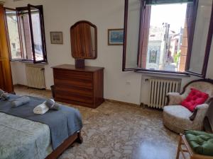 ein Schlafzimmer mit einem Bett, einem Spiegel und einem Stuhl in der Unterkunft Stefy's rooms in Venedig