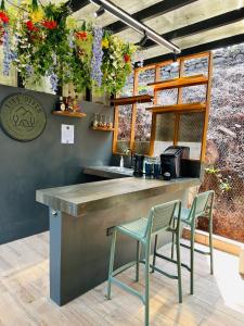 a kitchen with two chairs and a counter with flowers at Tiny Pines A-Frame Cabin, Domes and Luxury Glamping Site 