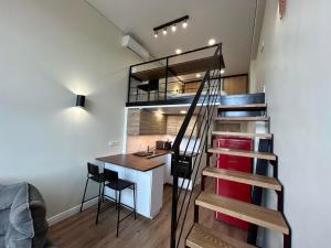 a stairway leading up to a loft with a desk at Stylish&Cozy Loft Žuvėdra near City Center in Vilnius