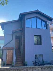 a white house with a door and stairs at Вила ОмниЯ in Chernomorets