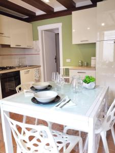 uma cozinha branca com uma mesa e cadeiras brancas em AL VICOLETTO em Verona