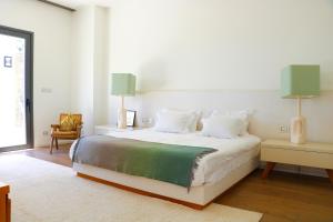 1 dormitorio con 1 cama blanca grande y 2 lámparas en Luxurious Coastal Villa with Pool Near the Beach by Sea N' Rent, en Herzliya
