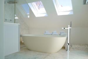 a large white bath tub in a bathroom with skylights at Luxurious Coastal Villa with Pool Near the Beach by Sea N' Rent in Herzliyya B