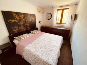 a bedroom with a bed and a clock on the wall at Villa Golda, The whole house Biker Friendly in Rijeka Reževići