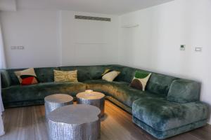 sala de estar con sofá verde y 2 mesas en Luxurious Coastal Villa with Pool Near the Beach by Sea N' Rent, en Herzliya