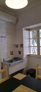 uma pequena cozinha com um lavatório e uma janela em Lagoas em Tavira