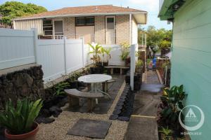 einen kleinen Hinterhof mit einem Tisch und einer Bank in der Unterkunft Hostel Honolulu in Honolulu