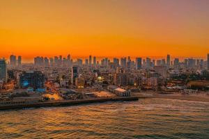 a view of a city at sunset from the water at Amazing Dizengoff Square Home in Tel Aviv