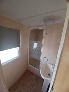 a bathroom with a sink and a toilet and a window at Seaview - 84 - Ingoldmells in Ingoldmells