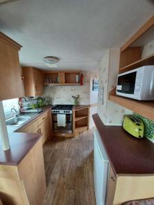 a small kitchen with a sink and a microwave at Seaview - 84 - Ingoldmells in Ingoldmells