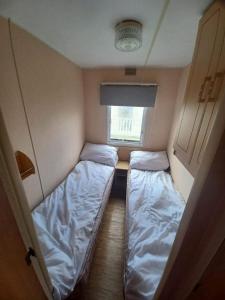 two beds in a small room with a window at Seaview - 84 - Ingoldmells in Ingoldmells