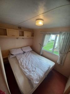 a bed in a small room with a window at Seaview - 84 - Ingoldmells in Ingoldmells