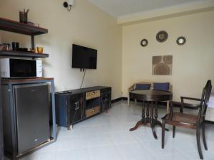 a living room with a table and a tv at Jogoo rooms in Dar es Salaam