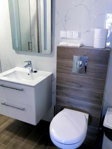 a bathroom with a white toilet and a sink at Apartament i pokoje gościnne Danuta in Ostrowo