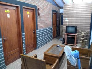 a room with a tv and a couch and a table at Homestay RnJ in Licin