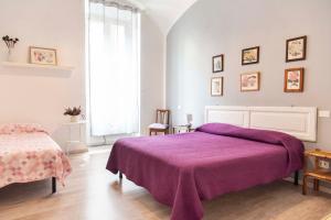 ローマにあるGarden Houseのベッドルーム(紫色のベッド1台、窓付)