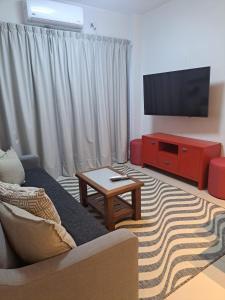 sala de estar con sofá y TV de pantalla plana en Divino departamento con garage en Corrientes