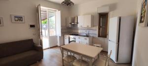 a small kitchen with a table and a refrigerator at OASIS ESCAPE in Vaccarizzo - Delfino