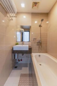 La salle de bains est pourvue d'une baignoire, d'un lavabo et d'une baignoire. dans l'établissement Mactan Newtown - 1BR Stunning Ocean View and City View, à Mactan
