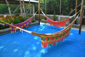 dos hamacas sentadas en una piscina de agua en Cabanas Villa Antonella Covenas, en Coveñas