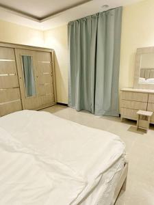 a bedroom with a bed and a dresser and a window at شقة جميلة مدخل جانبي دخول ذاتي 21 in Riyadh