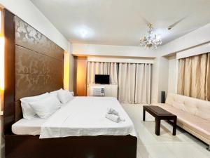 a bedroom with a large bed and a couch at Kiel 5-Star Condo Hotel Across NAIA Manila Airport Terminal 3 in Manila