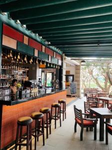 un restaurante con un bar con mesas y sillas en Chu Hotel, en Da Nang