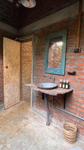 a bathroom with a sink on a brick wall at Nongu Home in Trincomalee