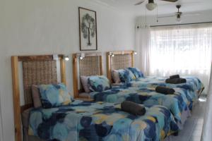 une chambre avec quatre lits et un canapé dans l'établissement Bush Lilly Cottage, à Hazyview