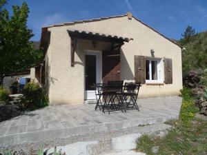 un patio con sedie e tavolo di fronte a una casa di gite les iris a La Robine