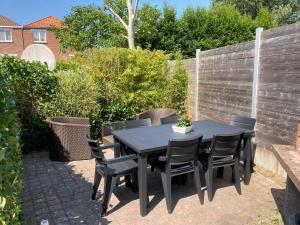 a black table and chairs on a patio at VILLA MICHRY Koksijde 4 adultes 2 enfants proche digue et centre in Koksijde