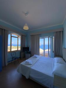 a bedroom with a large white bed and windows at Hotel Borgo Cacciatori in Ventotene