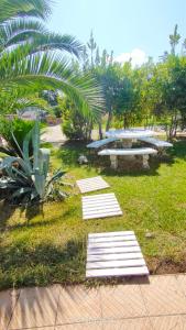 フランカヴィッラ・フォンターナにあるPupillo Casa Vacanzaの芝生の中のベンチとサーフボードがある公園