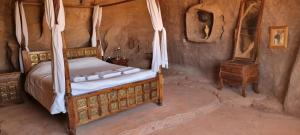 a bedroom with a canopy bed and a night stand at Obeid's Bedouin Life Camp in Wadi Rum
