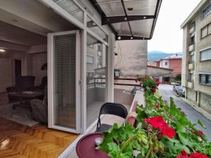 einen Balkon mit einem Tisch und Blumen auf dem Balkon in der Unterkunft Businoski's Apartment in Ohrid