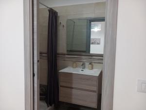 La salle de bains est pourvue d'un lavabo et d'un miroir. dans l'établissement Appartamento La Dama, à Scilla