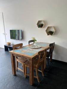 a dining room table with chairs and a television at Huisje36 in Middelburg