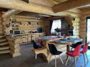 cocina con paredes de madera, mesa y sillas en Casa de Munte en Vatra Dornei