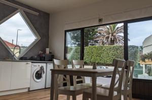 a kitchen and dining room with a table and chairs at Apartamento Mouzinho in Horta